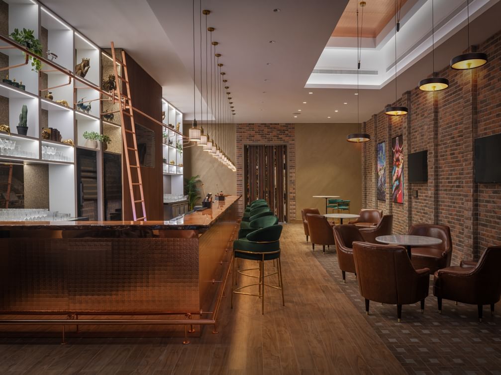 Bar counter area with high stools lined up in Melrose Bar & Lounge at Paramount Hotel Midtown