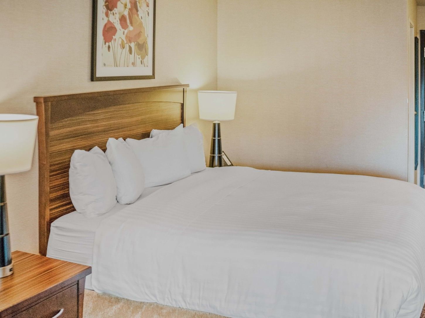 King bed with white linens and wooden headboard in a studio room at Crystal Inn Salt Lake City