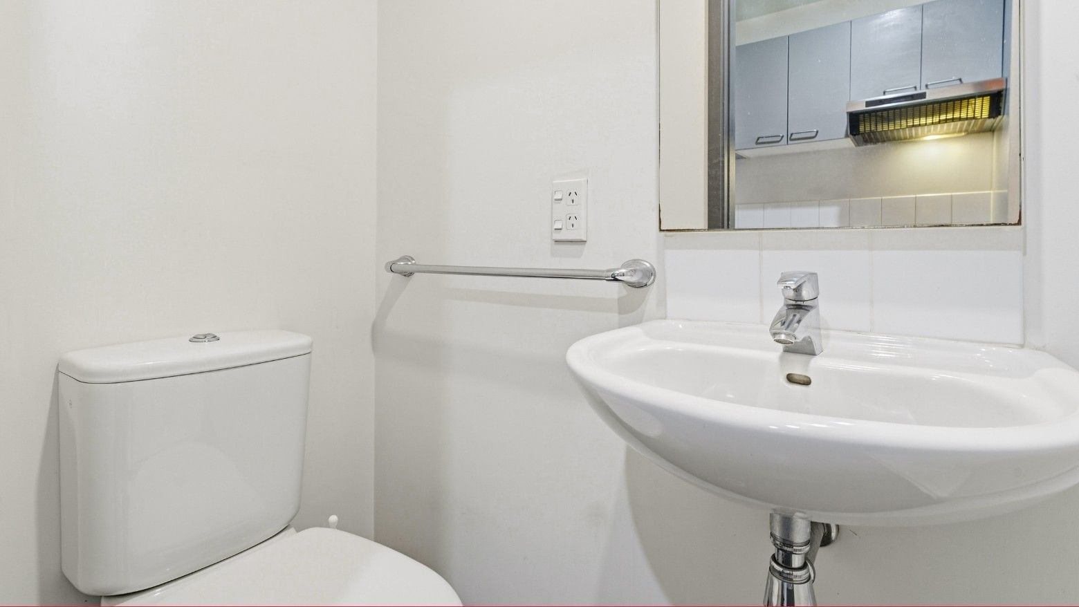 White toilet and sink in a bathroom at Student Living Auckland - Beach.