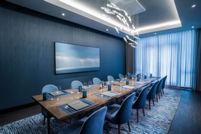 Dining table, chairs & large TV in Ovation at Innovation Hotel