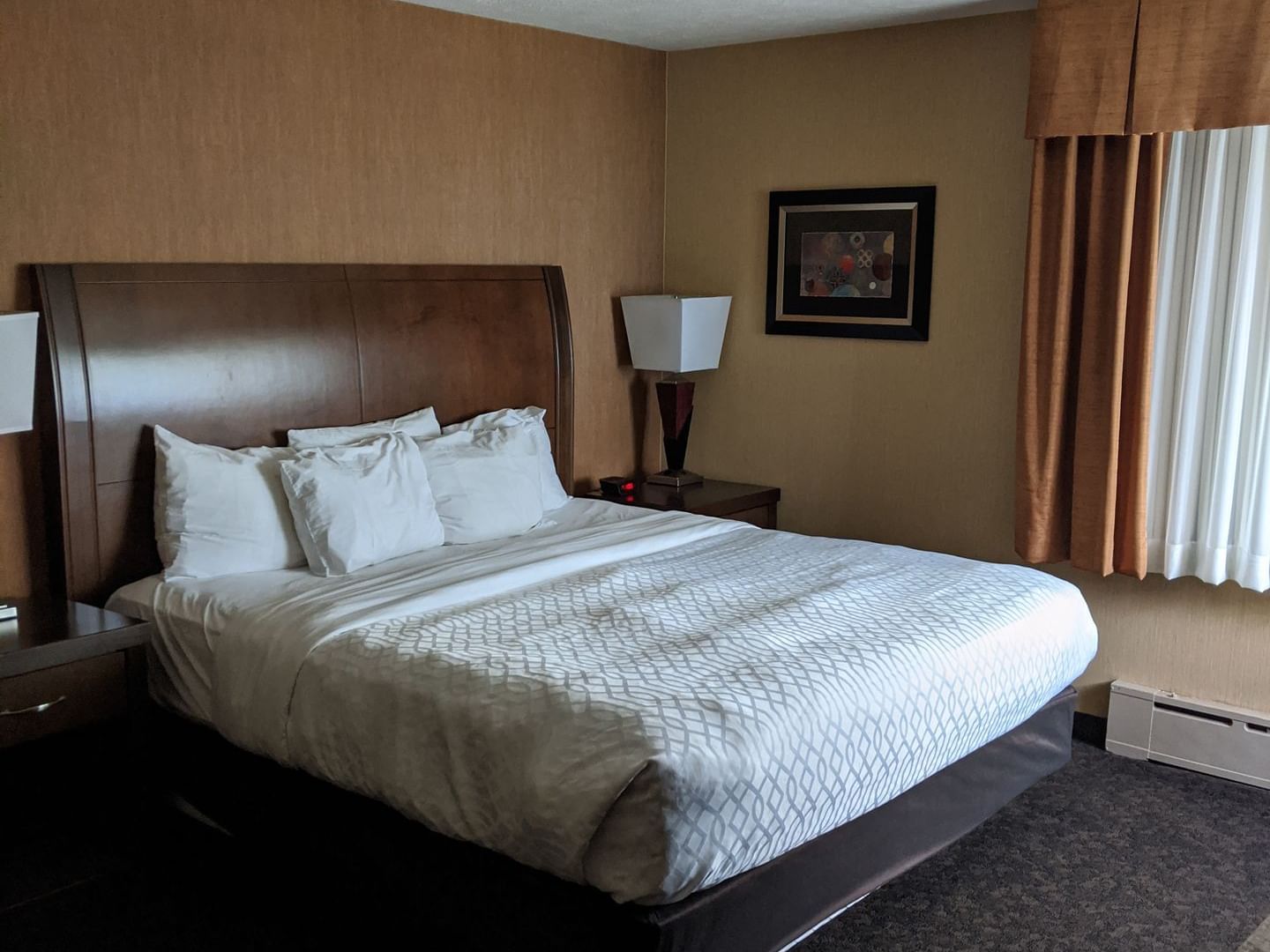 Junior King Suite with a bed and nightstands at Evergreen Resort in Cadillac.