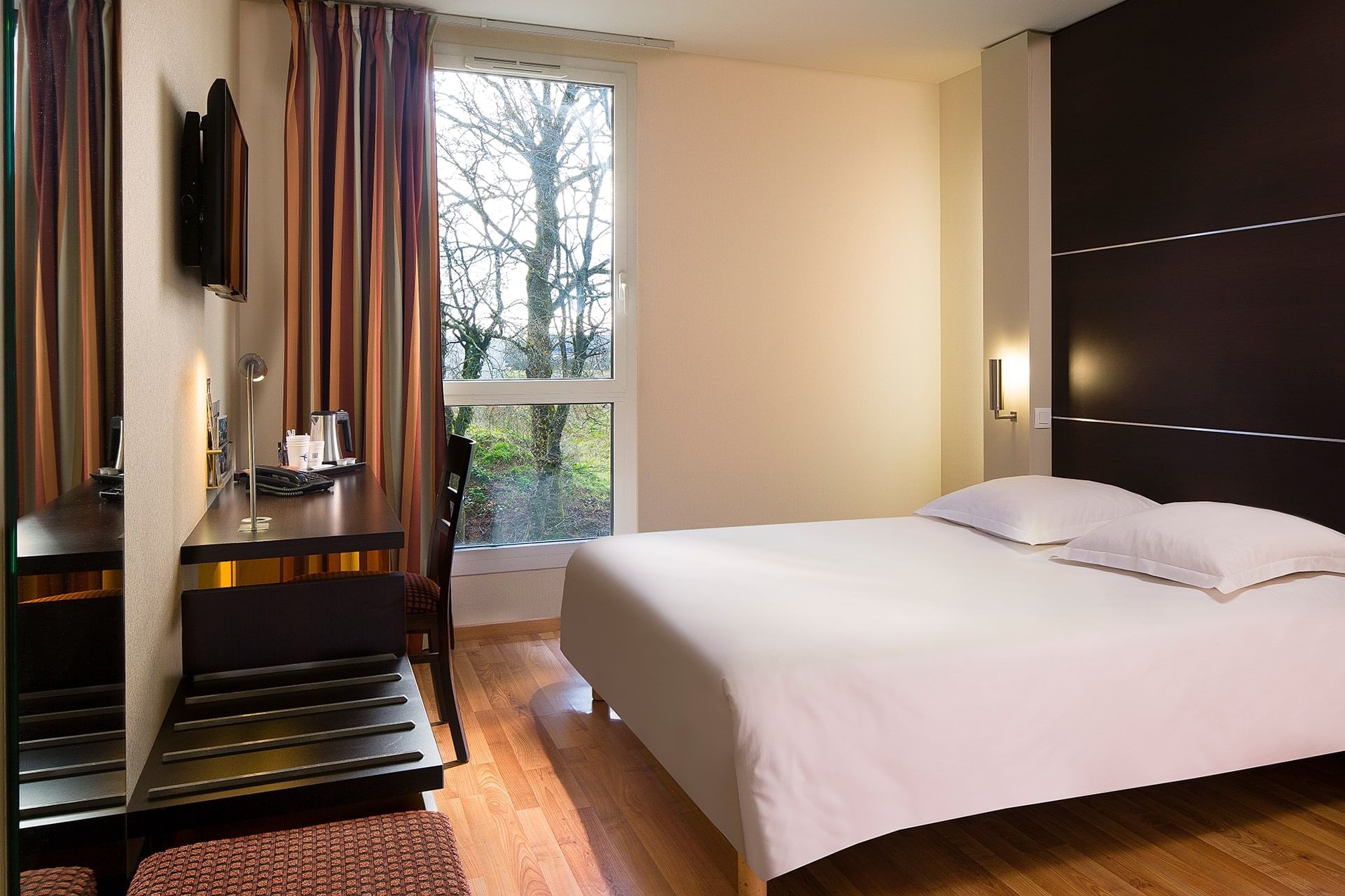 Lit king et bureau dans une chambre à Escale Oceania Rennes