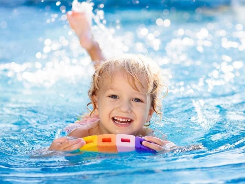 Un niño nadando en una piscina en Grand Fiesta Americana