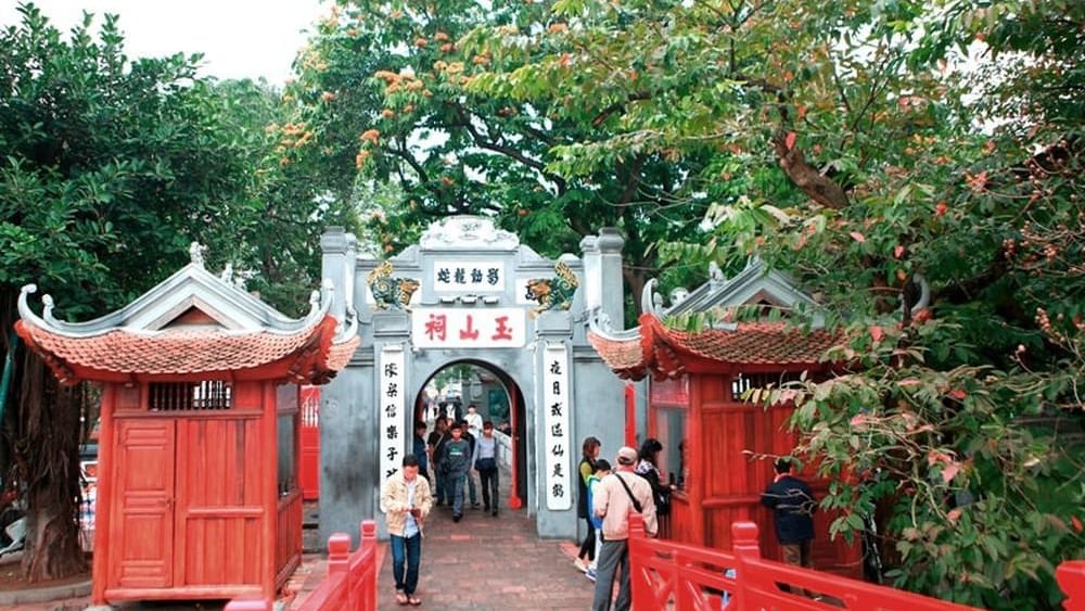 People crossing the wooden bridge in railing Ngoc Son Temple near Sunway Hotel Hanoi