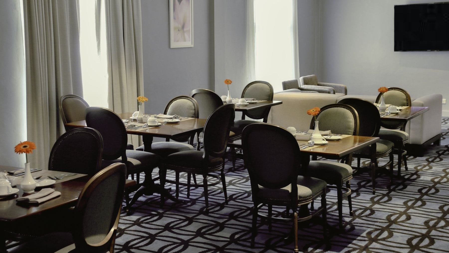 Dining tables & lounge area arranged in a hall at Gamma Hotels