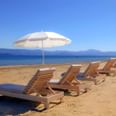 Exterior view of Cavomarina Beach coast with sun beds