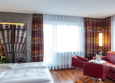 Bed, sofas & a bar table in Double Room at Hotel Sternen