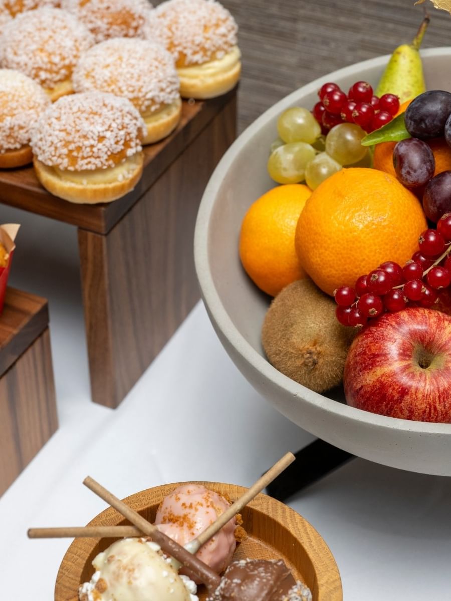 Bowl of fruit by sugar-dusted buns & muffins in Seminars & Banquets at Warwick Paris Champs Elysées
