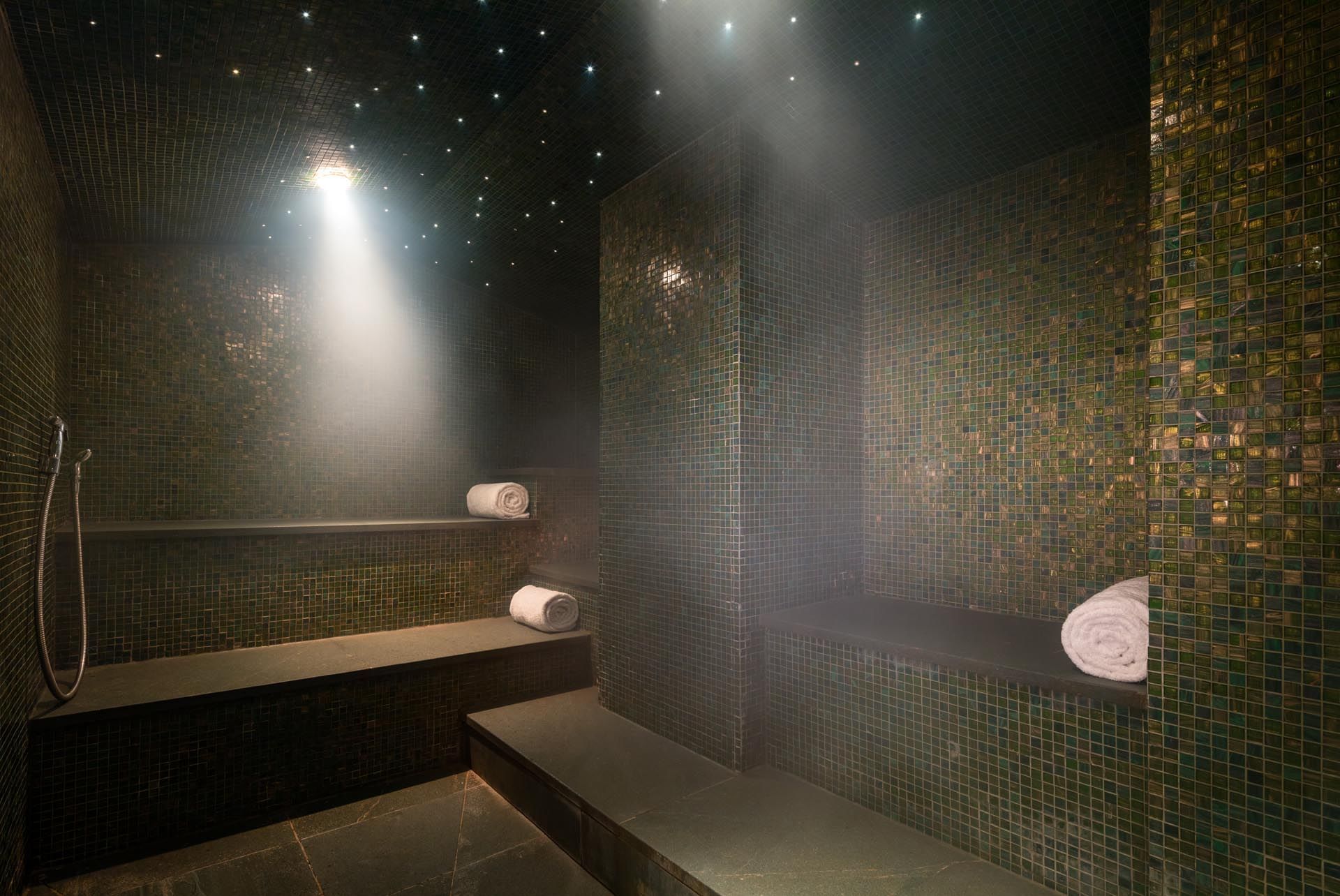 Steam room in May Fair Spa with benches and starry lights at The May Fair Hotel