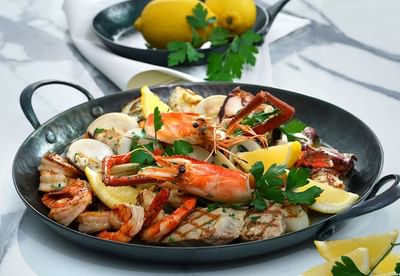 Seafood platter with shrimp, crab, octopus, clams, grilled fish, and lemon wedges in Opera Restaurant at Park Hyatt Saigon