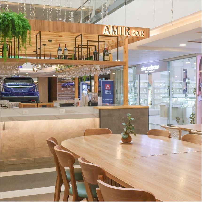 Interior de Amir Bar con mesas de madera, copas colgantes y barra moderna en Megapolis Hotel Panama