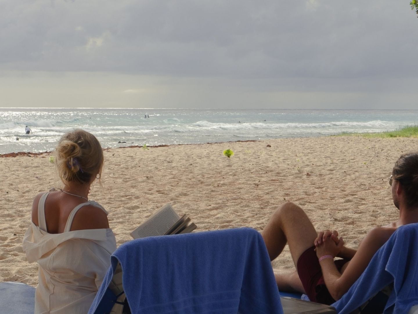 Two people relaxing on beach loungers with ocean view at Savannah Beach Hotel.