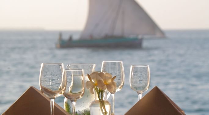 Wine glasses on a table by the sea at Zanzibar Serena Hotel