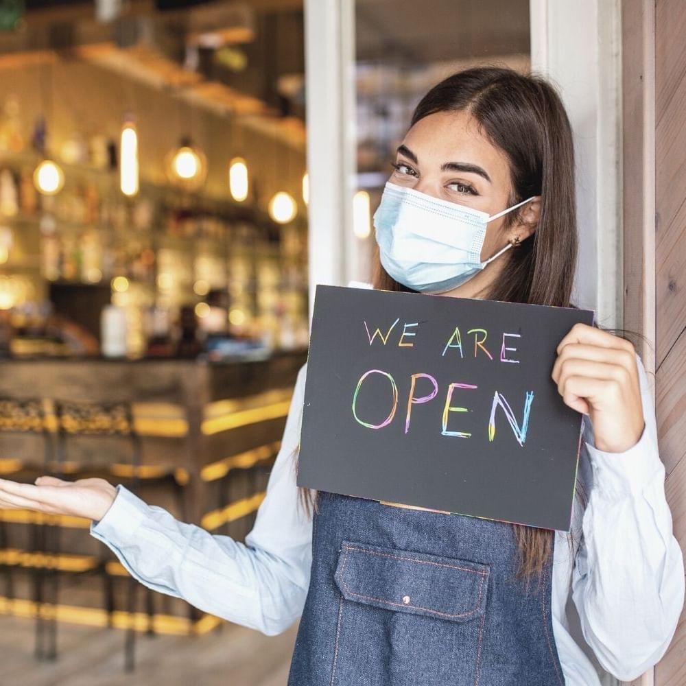Lady holding a sign by the restaurant entrance at Waikiki Resort Hotel by Sono
