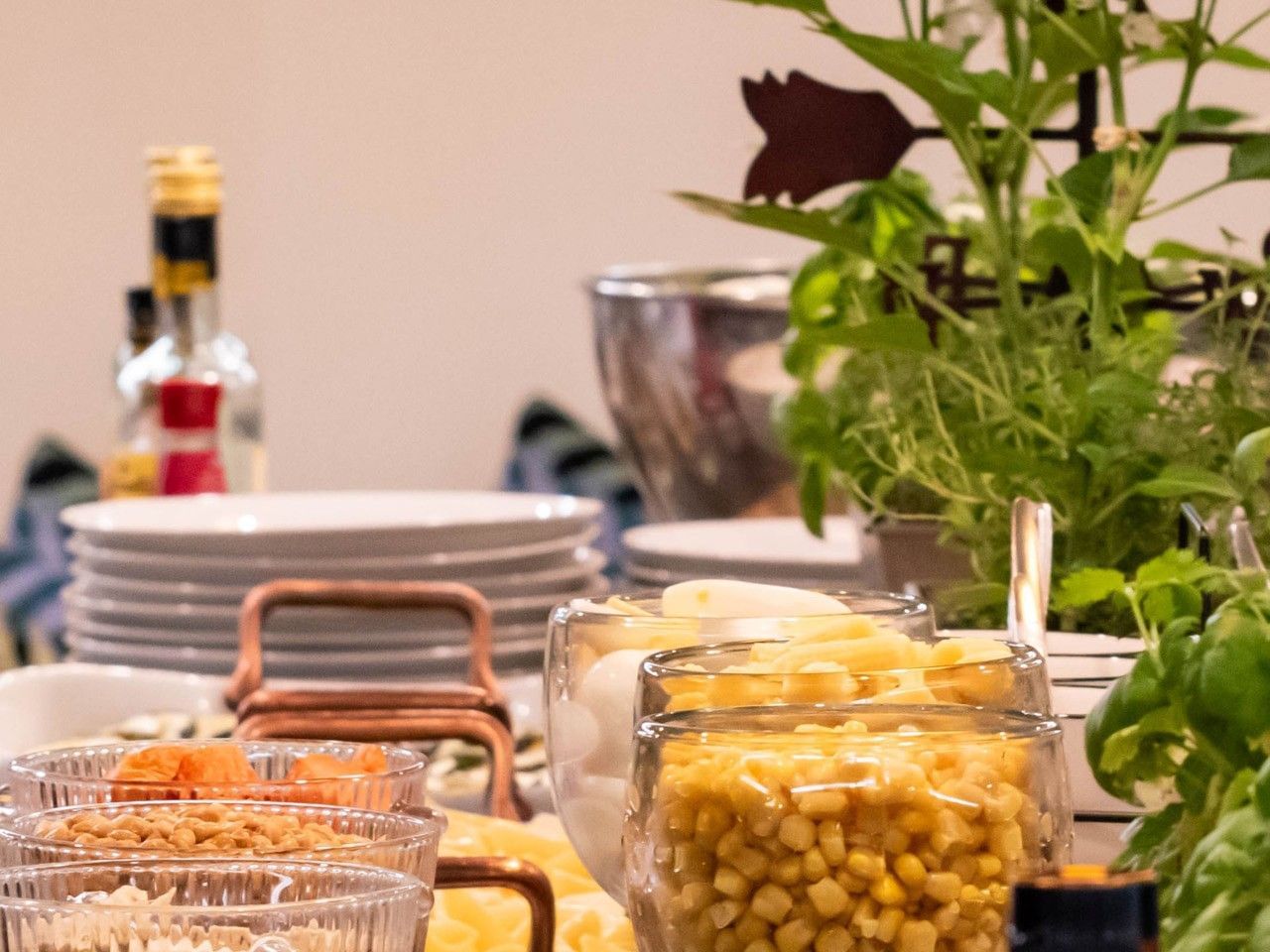 Buffet con platos variados, una planta y condimentos en el hotel HCC Costanera Concepción.
