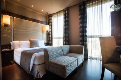 Bed & furniture in Superior Queen Room at Uptown Palace