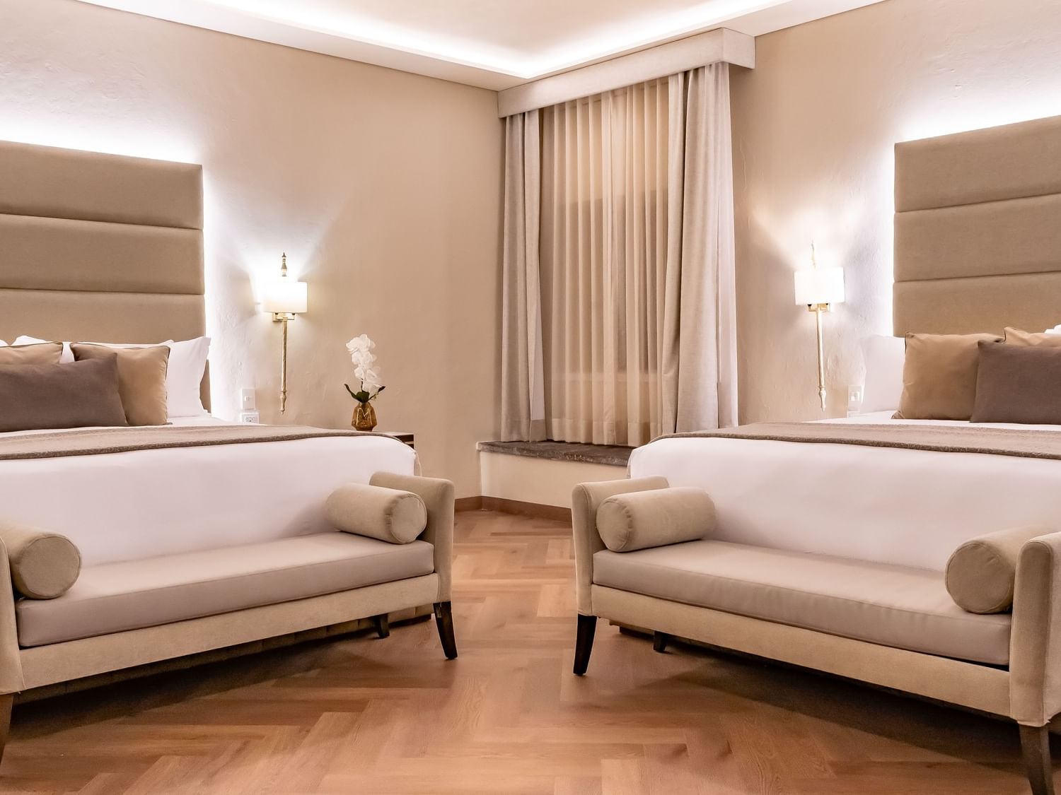 Two luxurious king-sized beds with soft cushions and pillows at Quinta Real Puebla in Heroica Puebla de Zaragoza.