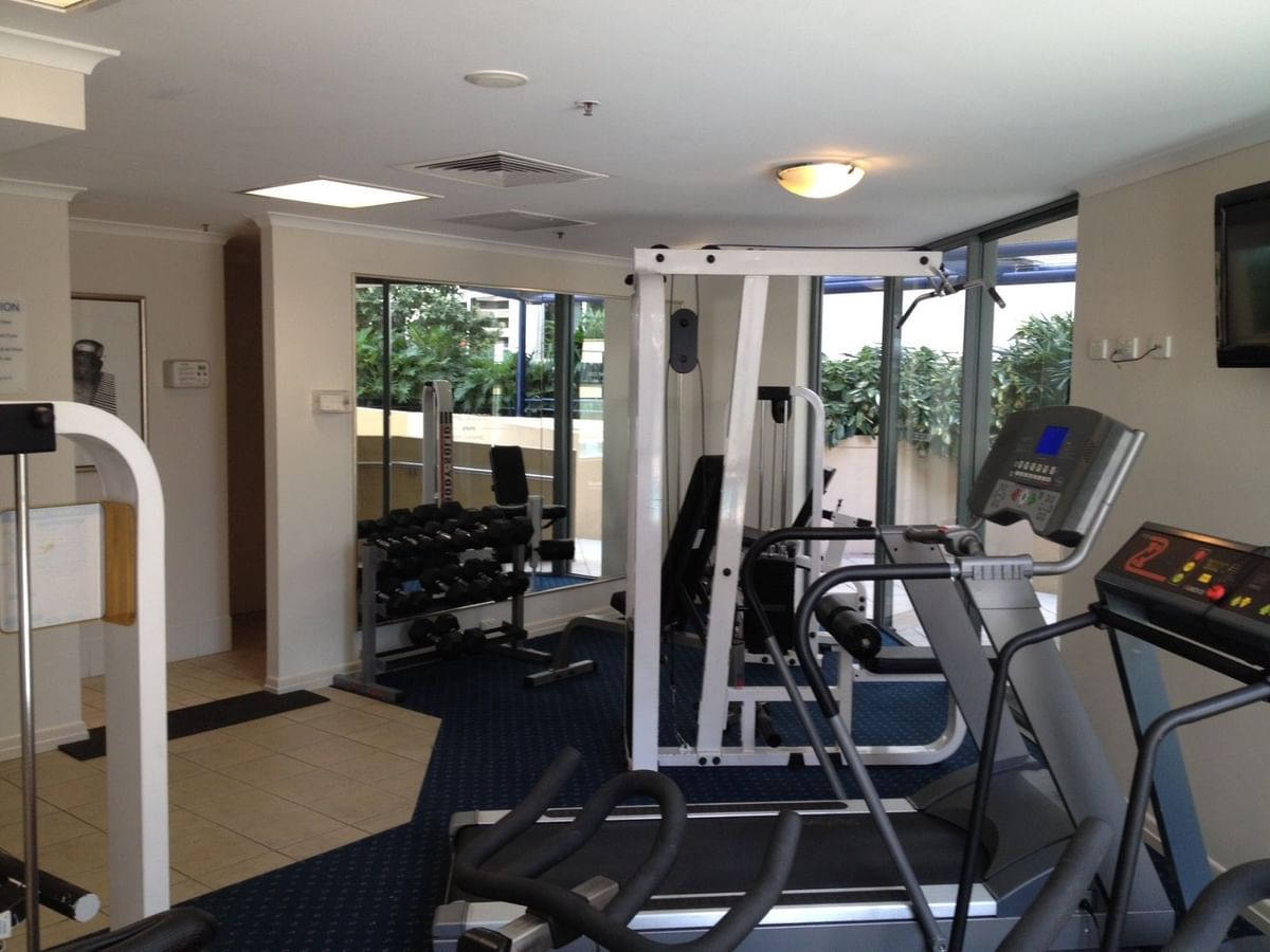The Gym with cardio machines, weight racks, and a mirrored wall at the well-equipped fitness center of The Sebel Brisbane