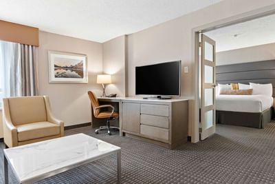 carpeted living room with tv and door to bedroom