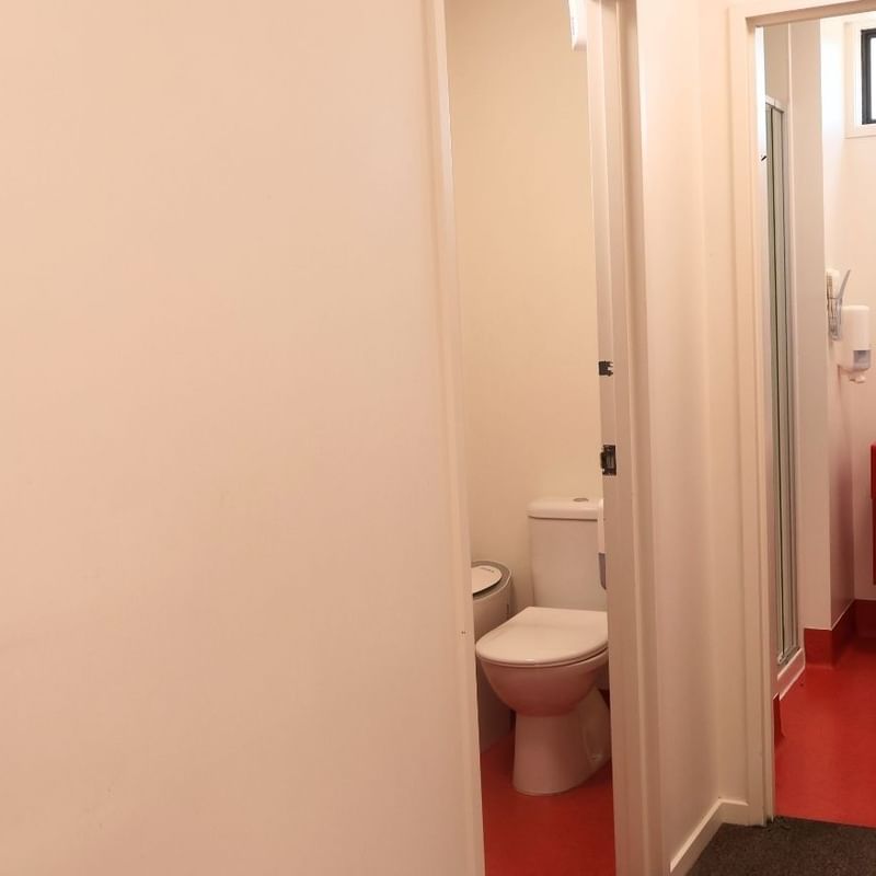 Red and white bathroom with toilet and sink at La Trobe University Hillside Apartments.