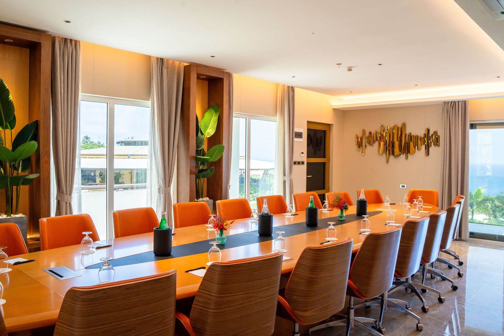 St. Barths boardroom met een grote ovale tafel, oranje stoelen en glazen ramen in Golden Rock Resort