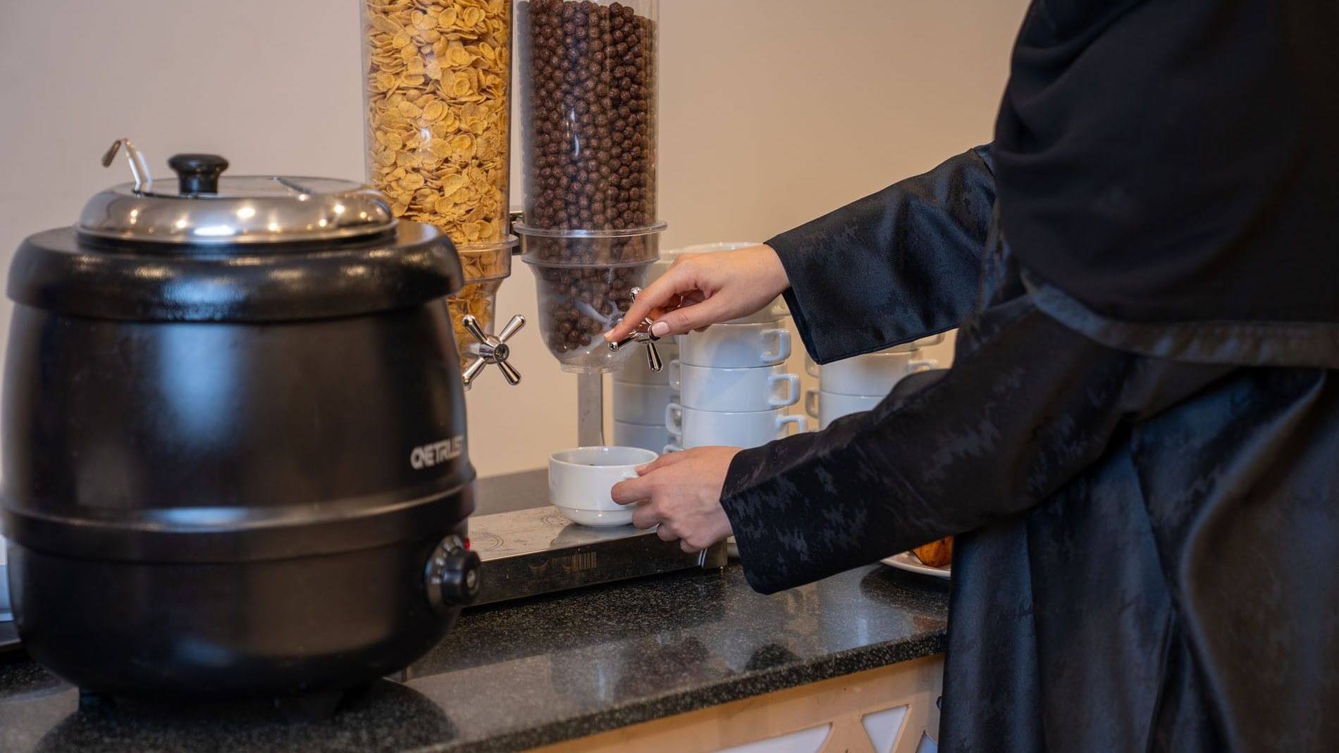 Woman pouring coffee at the All-Day Dining Restaurant in Saja by Warwick Makkah.