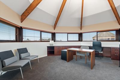 Workspace with tables and carpeted floors in the Three Bedroom Riverview Penthouse at Amora Herencia Riverwalk Melbourne