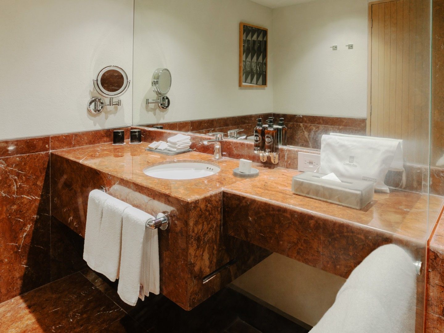 King Deluxe Plus red marble vanity with round sink, large mirror, and plush white bath towels at Camino Real Polanco Mexico