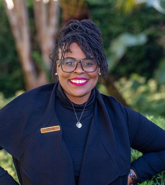 Misha Paul wearing glasses in a black outfit with name tag at Rosen Inn at Pointe Orlando outdoor