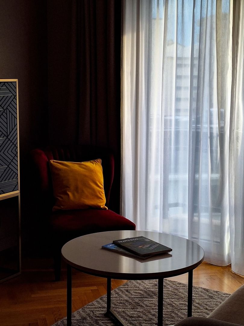 Living area with side cupboard and plush seating in the Premium Suite at Warwick Reine Astrid - Lyon