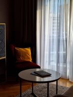 Living area with side cupboard and plush seating in the Premium Suite at Warwick Reine Astrid - Lyon