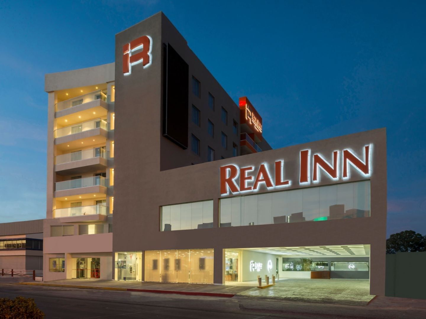 Real Inn Celaya facade showcasing modern architecture and glowing lights at twilight