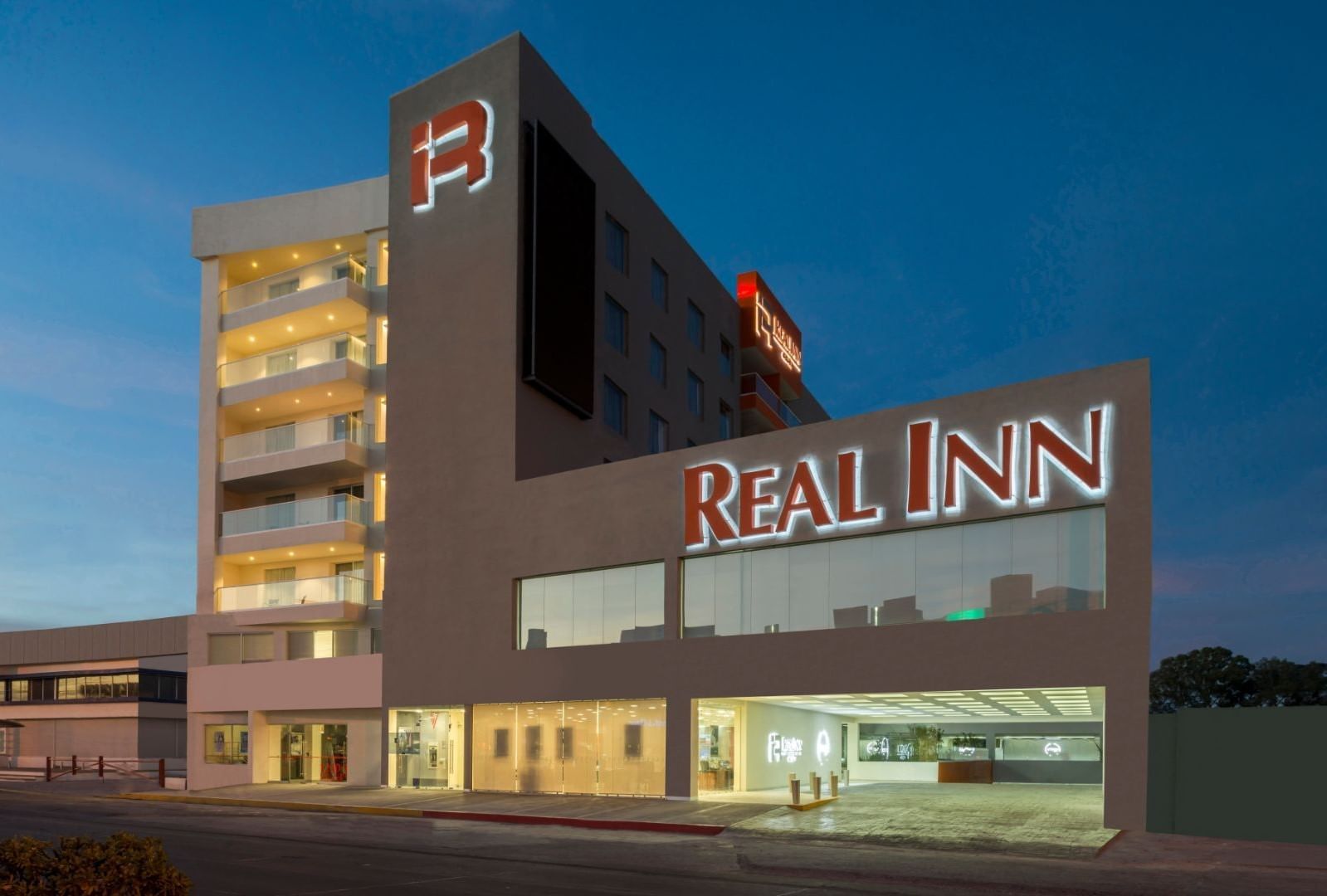 Real Inn Celaya facade showcasing modern architecture and glowing lights at twilight