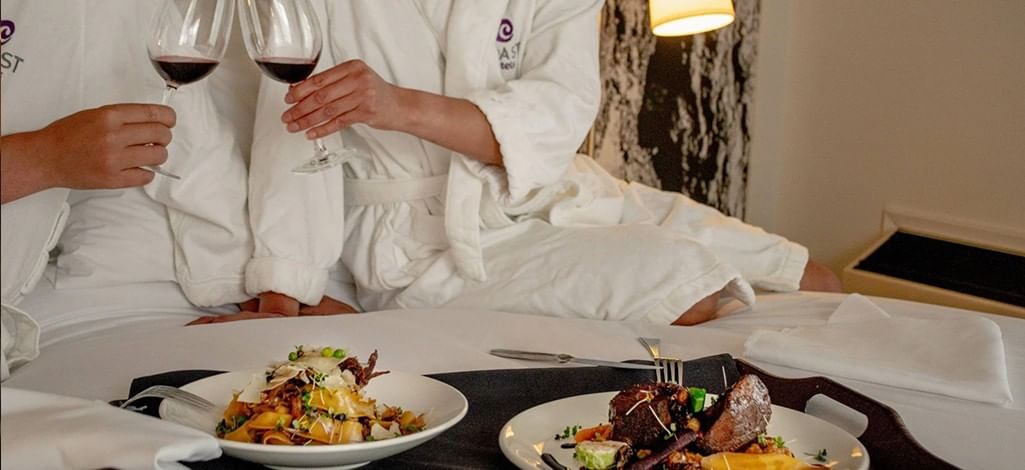 A couple enjoying room service in their Canmore hotel after a long say of skiing.