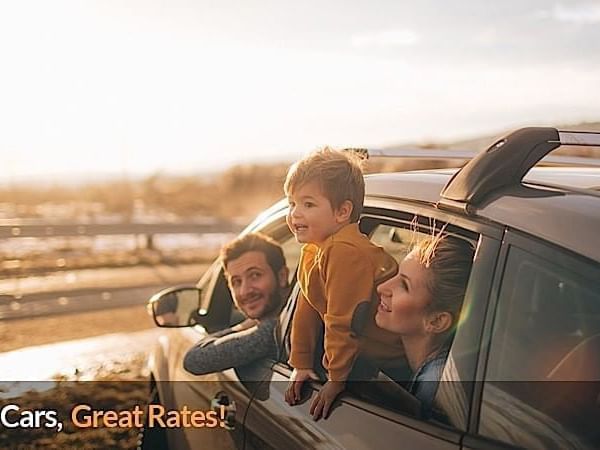 Family looking around in the car with sunshine near Applause Hotel Calgary