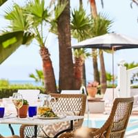 Dining arrangement by a pool in Beach Club at Marbella Club