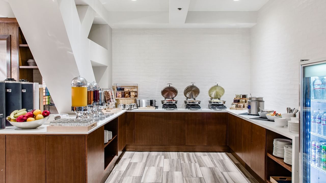 Executive Lounge with hot food, fruits, and a fridge with drinks