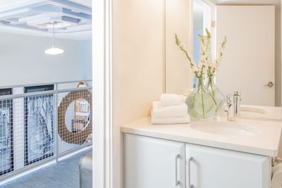 Bathroom vanity, handrail & overview of the living area in Superior Loft Sail Inn at Retro Suites Hotels