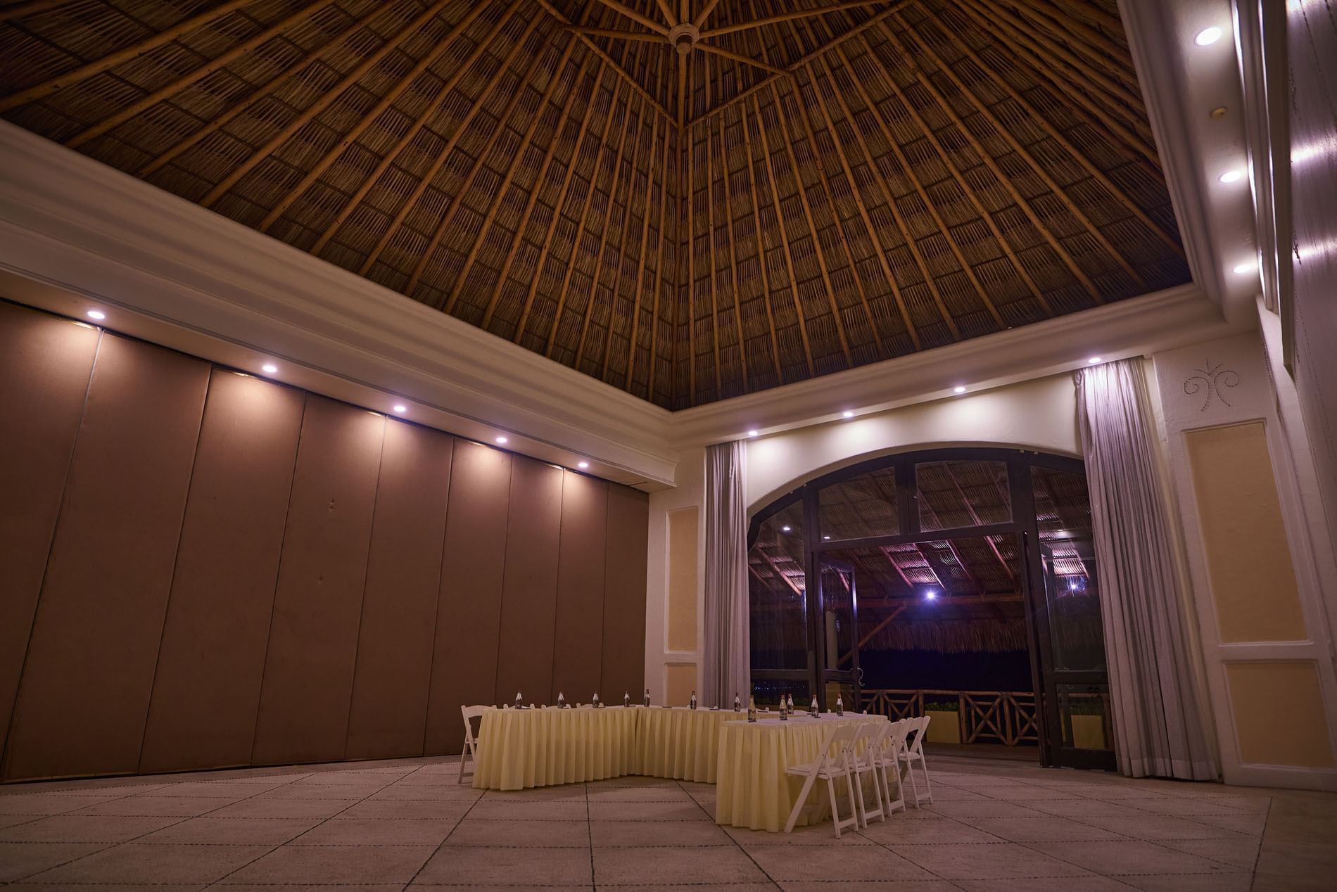Professional Ixtac Venue set up with white tables and chairs under a high roof at Quinta Real Acapulco