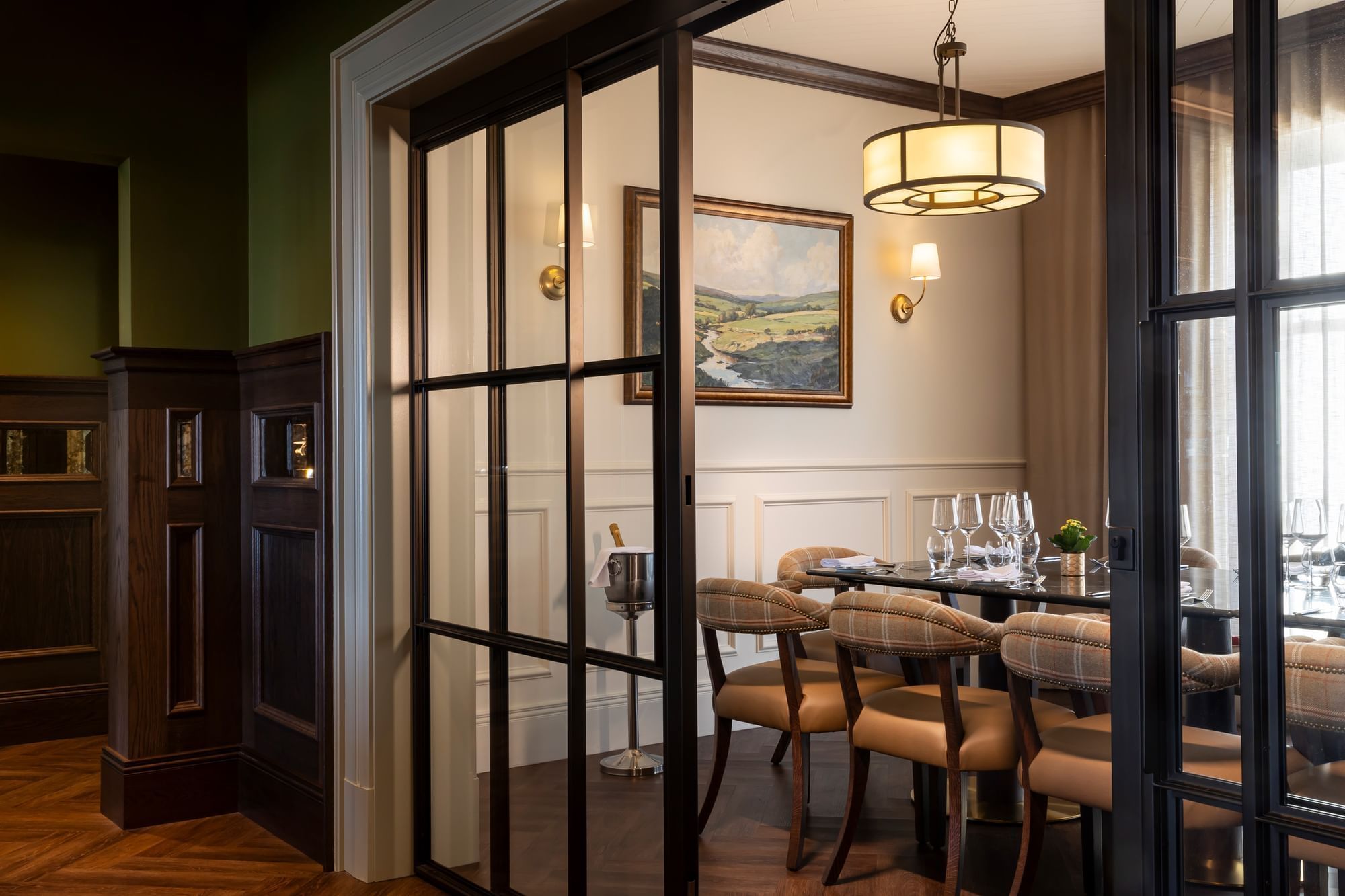 The elegant private dining room at Dunluce Lodge, featuring a round table and large glass-paned doors