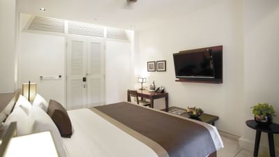King bed facing a wall TV in a Suite at Amara Sanctuary Resort
