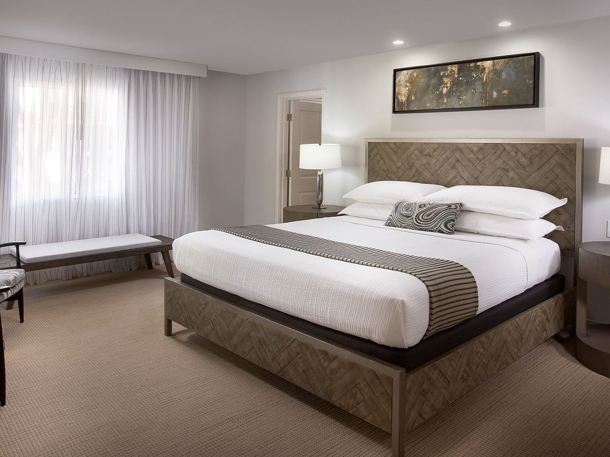 Hotel guestroom featuring a bed, a chair, and a nightstand