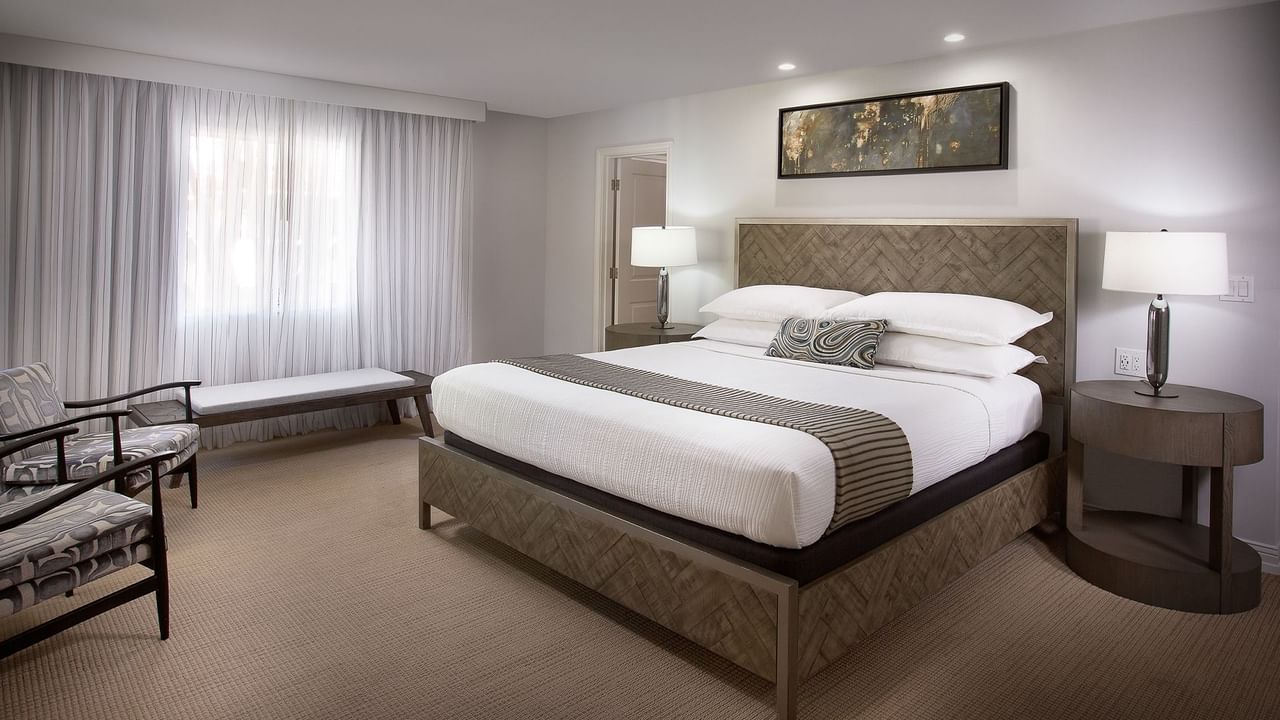 Hotel guestroom featuring a bed, a chair, and a nightstand