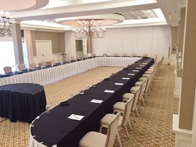 U-shaped conference setup with individual place settings under large chandeliers at The Simsbury Inn 