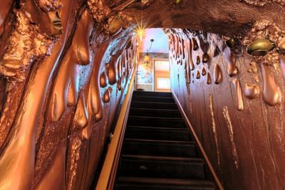A staircase flanked by walls featuring glossy, metallic drips in Melt With You at The Roxbury