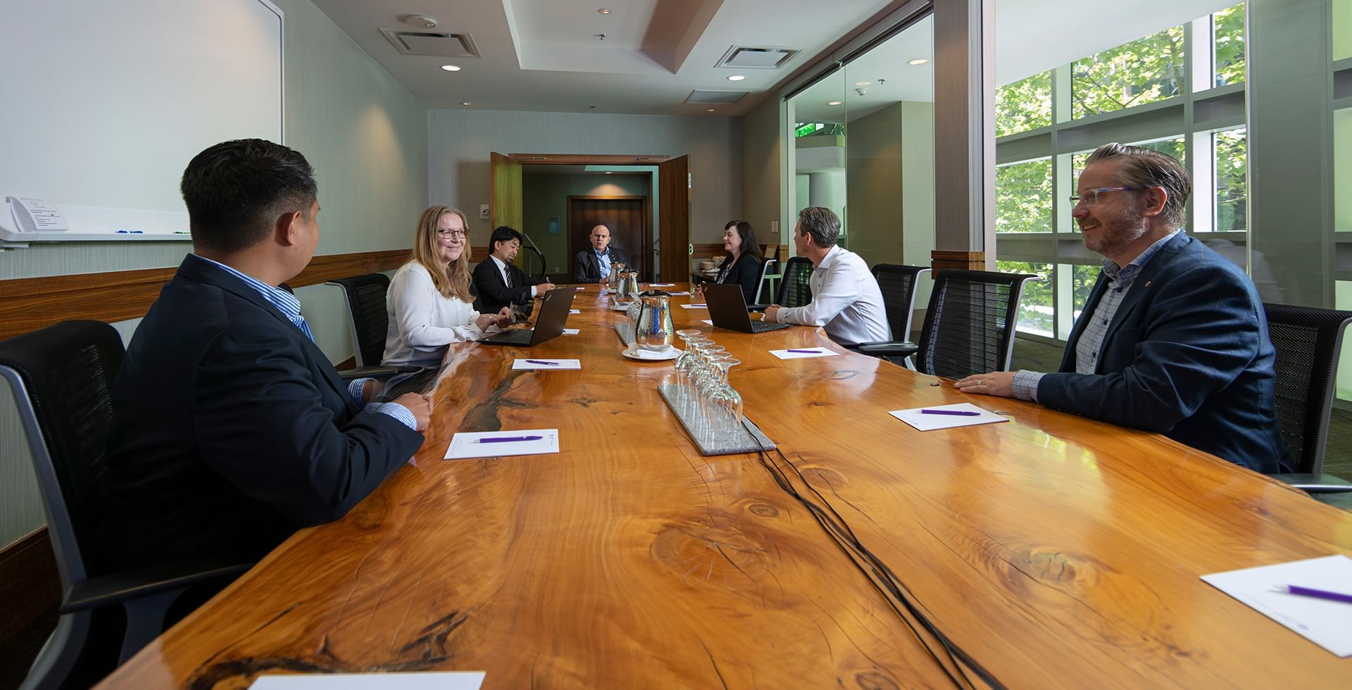 people sitting at the wooden table inside the Canoe Room located in the Coast Coal Harbour Hotel Vancouver