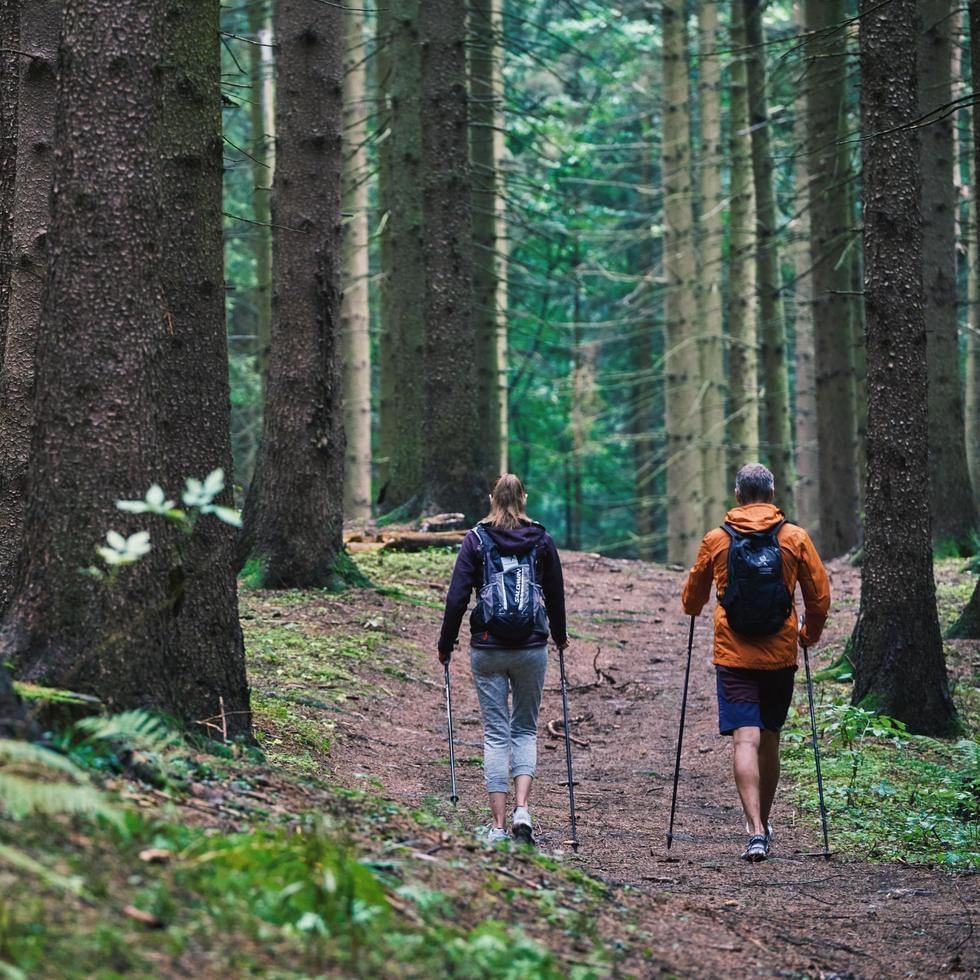 A couple walking in a mountain trail near Falkensteiner Hotels