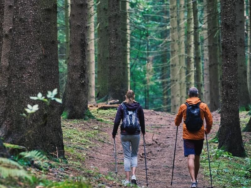 A couple walking in a mountain trail near Falkensteiner Hotels