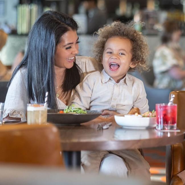 Kids enjoying meals with their parents in a restaurant at Pullman Albert Park