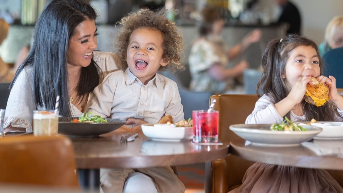 Kids enjoying meals with their parents in a restaurant at Pullman Albert Park